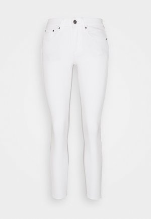 Jeans skinny bianchi con una texture liscia, design a cinque tasche, zip sul fronte e chiusura con bottone in ottone. Presentano una cucitura sottile color cammello e nessun logo visibile.