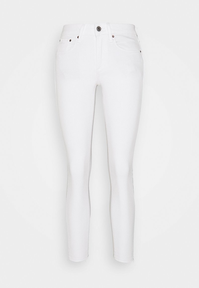 Jeans blancos ajustados con una textura suave, diseño de cinco bolsillos, cierre con cremallera y botón de latón. Presenta costuras en tono beige sutil y sin logotipos visibles.
