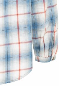 Chemise à manches longues avec un motif écossais bleu, rouge et noir, poignet à boutons et tissu texturé.