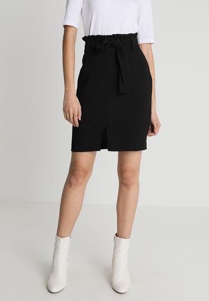 Czarna dopasowana spódnica z falbanianym paskiem w talii i przednim rozcięciem. Noszona z białą bluzką i białymi botkami za kostkę. Gładka tkanina, elegancki fason.