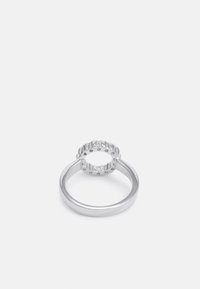 Silverring med en polerad band och en kronliknande topp som har texturerade toppar och små cirkulära utskärningar för extra detalj.