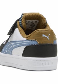 PUMA sporta apavi ar melnu, baltu un zilu ādas augšdaļu, ar Velcro siksniņu, teksturētu brūnu papēdi un balto zoli ar logotipu.