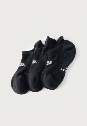 Trei perechi de șosete negre pentru gleznă cu logo-uri Nike albe, așezate în stivă pe un fundal alb, prezentând diferite unghiuri ale fiecărei șosete.
