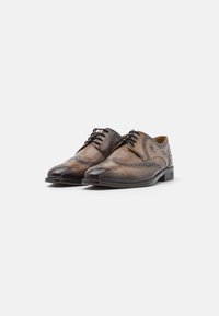 Scarpe brogue in pelle marrone con dettagli perforati, punta arrotondata, accenti scuri a contrasto e chiusura con lacci.