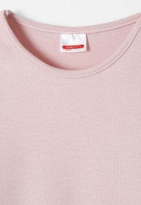 T-shirt en coton rose clair avec un col rond, une texture lisse et une étiquette avec des accents rouges indiquant "THERMOLACTYL par DAMART."