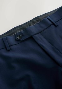 Marineblaue Hose mit glatter Textur, Knopfverschluss, klaren Linien und tailliertem Bund für einen figurschmeichelnden Look.