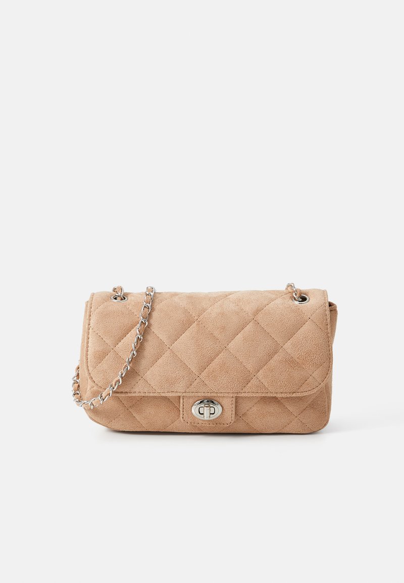 Tan suede quilted handbag with a silver chain strap and a circular clasp. Features a rectangular shape and soft texture.