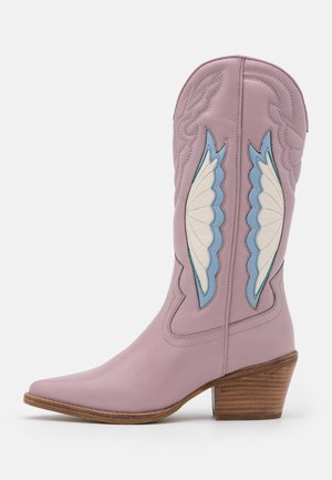 Botte de cowboy en cuir lilas avec un bout pointu, un talon en bois, et des accents d'aile brodés en bleu et blanc sur les côtés. Design texturé.