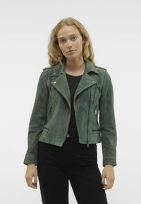 Grüne Wildleder-Bikerjacke mit Reißverschlusstaschen, spitzem Kragen und Schulterklappen, in einer taillierten Silhouette gestaltet.