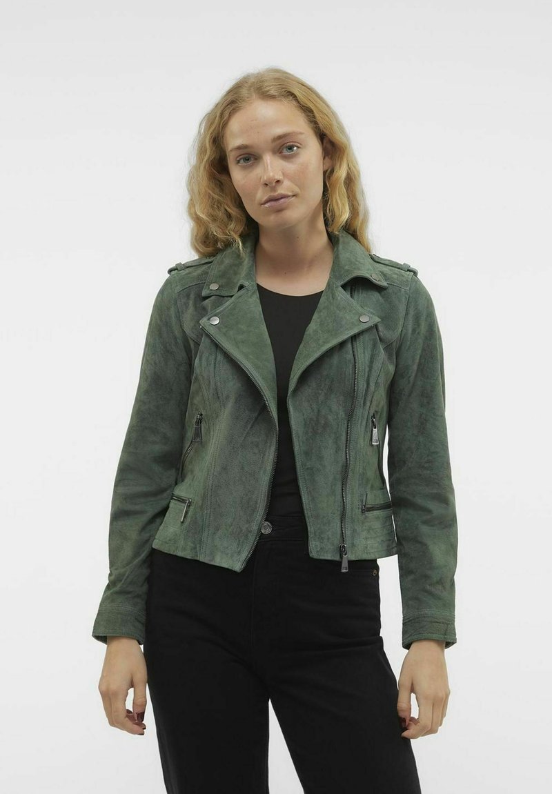 Grüne Wildleder-Bikerjacke mit Reißverschlusstaschen, spitzem Kragen und Schulterklappen, in einer taillierten Silhouette gestaltet.