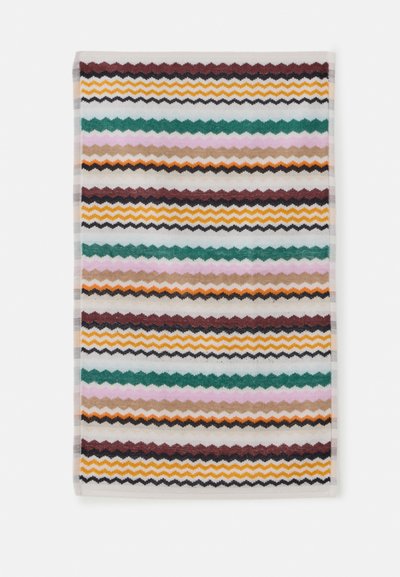 Serviette rectangulaire avec des rayures zigzag horizontales en bordeaux, jaune moutarde, noir, vert, rose, beige et orange sur fond blanc.