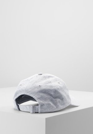 Light gray fabric baseball cap with adjustable strap, resting on a white surface against a plain light gray background.