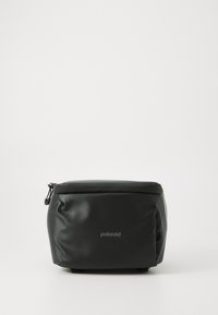 Černá obdélníková taška na fotoaparát vyrobená z hladkého materiálu. Obsahuje zipový vršek, logo Polaroid a kompaktní, polstrovaný design.