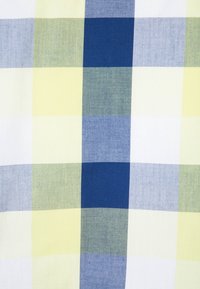Tessuto a scacchi con quadrati di giallo chiaro, bianco, blu chiaro, blu scuro e verde chiaro. Texture liscia con un aspetto simile al cotone.