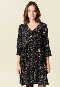 Schwarzes Kleid mit floralem Muster in Creme-, Blau- und Rosttönen. Verfügt über einen V-Ausschnitt und Dreiviertelärmel, fließende, entspannte Passform.