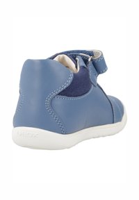 Scarpa in pelle blu con accento in tela, punta arrotondata, fascia in Velcro e suola in gomma bianca. Presenta dettagli cuciti e logo del marchio sul tallone.