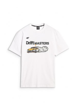 Kobieta nosząca białą koszulkę "Drift Masters" z grafiką driftingowego samochodu oraz czarne spodnie typu cargo z naszywkami z logo, stojąca z jedną ręką w kieszeni.