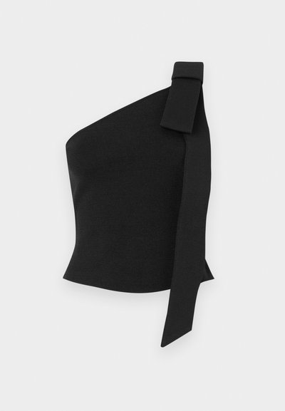 Aszimmetrikus fekete felső, texturált anyagból; bal vállán masnis díszítéssel és testhez simuló kialakítással rendelkezik.