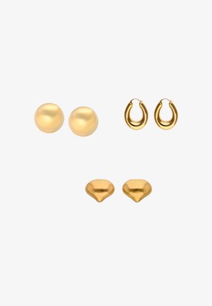 Trzy pary złotych kolczyków: gładkie okrągłe sztyfty, małe grube koła w kształcie kropli oraz nieregularnie ukształtowane kolczyki kopułkowe na białym tle.