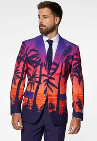 Blazer de colores brillantes con un degradado de púrpura a naranja, adornado con siluetas de palmeras y bolsillos con botón. Textura de tela suave.
