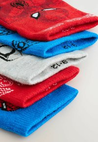 Pile de chaussettes colorées pliées, avec des motifs de Spider-Man et d'araignées en rouge, bleu, gris et blanc sur une surface claire.