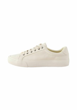Beige lage canvas sneaker met vetersluiting en witte rubberen zool, gezien vanaf de binnenkant tegen een witte achtergrond.