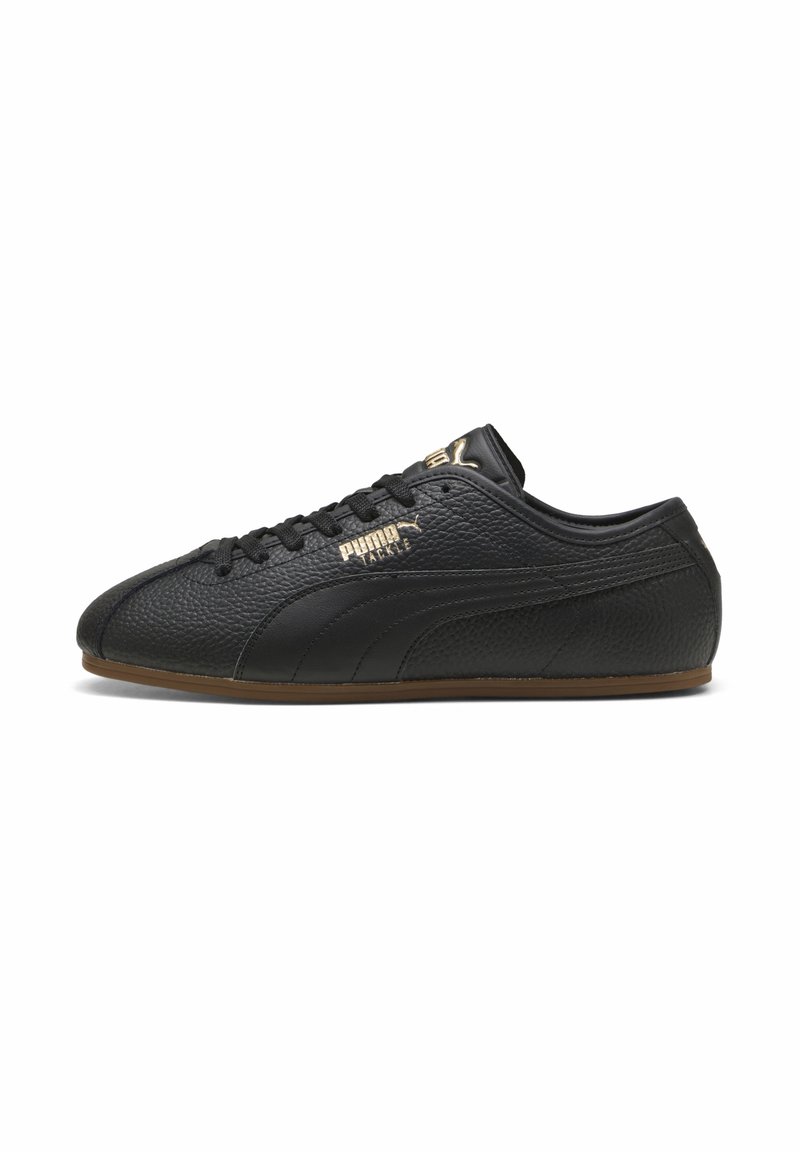 Baskets Puma en cuir noir texturé avec logo doré et semelle en gomme, vues de côté extérieur avec lacets noués.