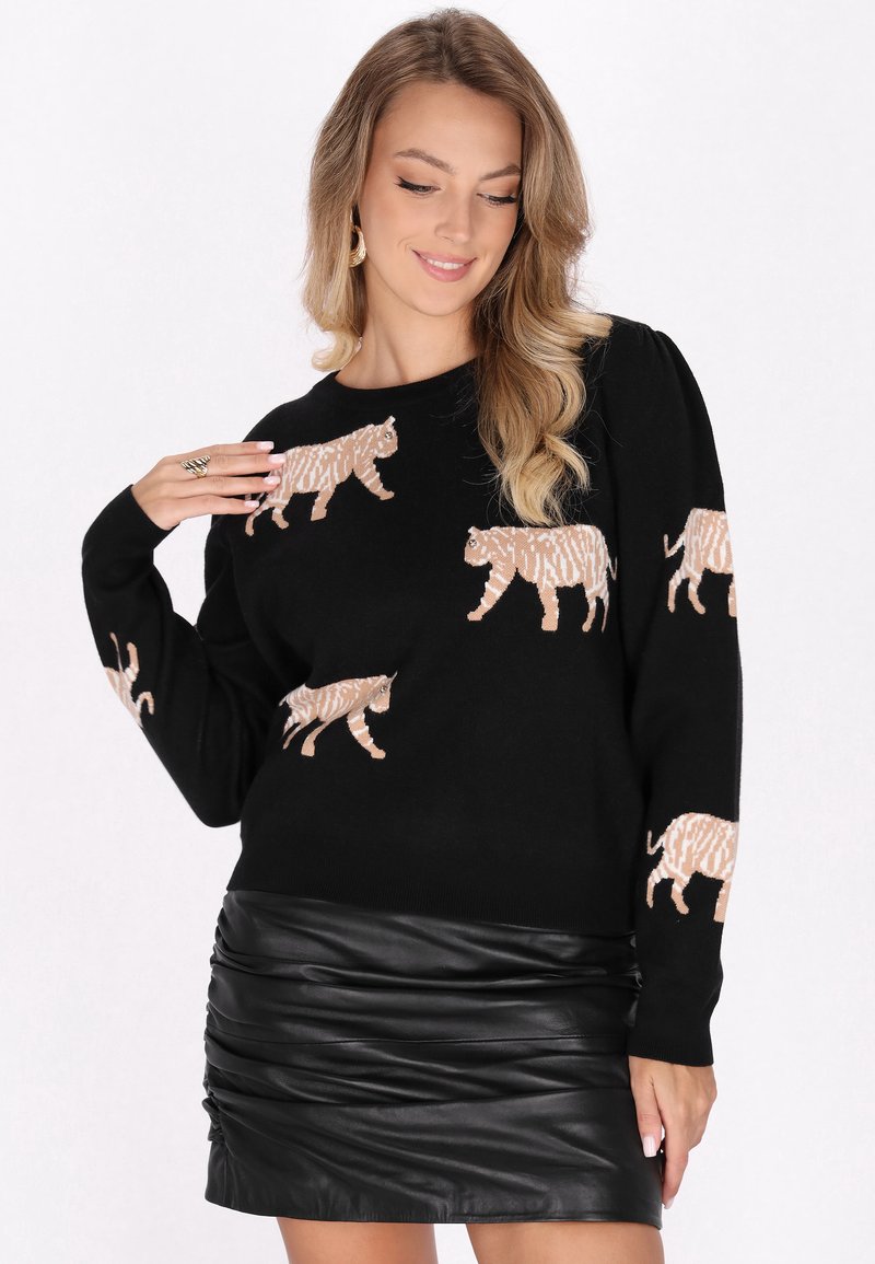 Maglione nero con una grafica di tigri in color beige, maniche lunghe, scollatura a coste, abbinato a una minigonna di pelle nera con arricciature.