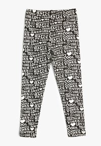 Leggings negros con un patrón de texto repetido en blanco, que muestra palabras como "AMOR", "PAZ" y "FELICIDAD" en varios tamaños y estilos.
