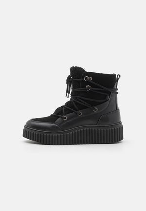Černé kozačky s koženým a textilním svrškem, texturovanou podrážkou, šněrováním a fleecovou podšívkou, se širokou rýhovanou platformou.