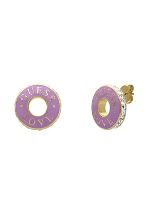 Boucles d'oreilles clous en ton or avec un motif circulaire et un centre en émail violet. Les mots "GUESS LOVE" sont embossés, soulignés par des cristaux.