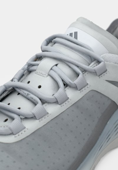 Αθλητικό παπούτσι ανοιχτό γκρι με λείο δερμάτινο επάνω μέρος, υφασμάτινες λεπτομέρειες, επίπεδα κορδόνια και επενδεδυμένη γλώσσα με λεπτομέρεια λογότυπου.