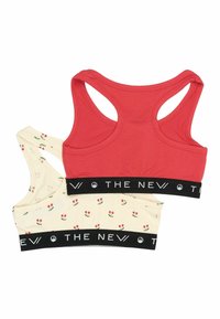 Par raste z brusom s racerbackom, jedan crven, a drugi krem sa cvjetnim uzorcima. Obe imaju crni elastični pojas s natpisom "THE NEW." Mekana tekstura tkanine.