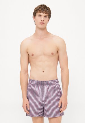 Herrenschwimmshorts in burgunderrot mit weißen vertikalen Streifen. Mit einem elastischen Bund und einem lockeren Schnitt ausgestattet. Aus leichtem Material gefertigt.