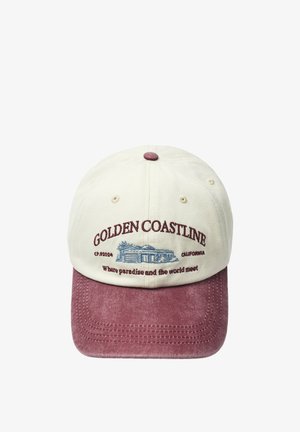 Casquette de baseball avec couronne crème et visière rose poussiéreuse, avec texte brodé "GOLDEN COASTLINE" et illustration d'une maison.