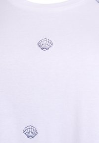White cotton t-shirt with a round neckline featuring multiple blue embroidered seashell designs evenly distributed across the fabric.