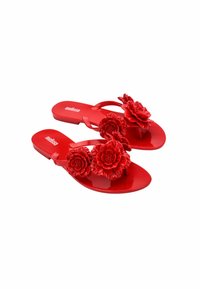 Sandali piatti rossi in plastica lucida, con decorazioni floreali tridimensionali sulla fascia superiore. Tessuto liscio, design minimale.
