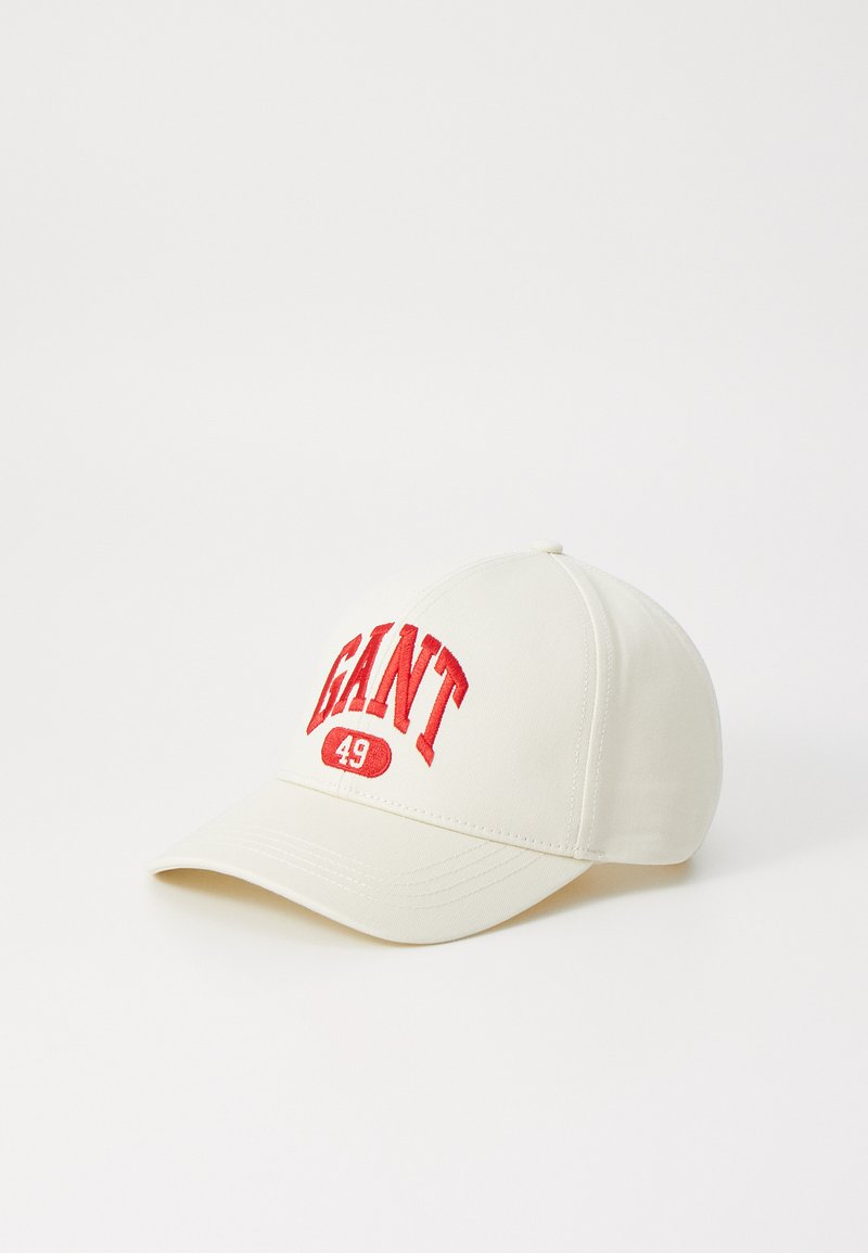 Un capac de baseball bej cu o vizieră curbă, având textul brodat roșu "GANT 49" pe partea din față. Materialul are o textură netedă.