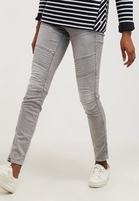 Jeans ajustados grises de mezclilla con acentos acanalados en los muslos, que presentan un corte slim y un ligero estiramiento para mayor comodidad.