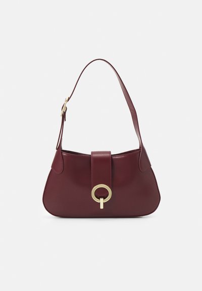 Borsa a tracolla in pelle borgogna con forma curva, accentuata da un hardware oro circolare e una singola tracolla. Texture liscia, design minimalista.
