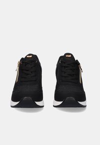 Zapatillas deportivas negras con parte superior texturizada, diseño de cordones, cremallera lateral, acentos dorados y suela de goma blanca.