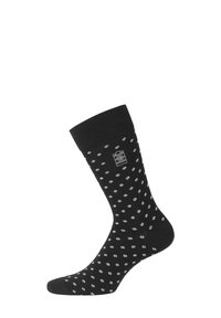 Chaussette noire à la cheville avec un poignet côtelé, présentant un motif à pois blancs et un petit logo au niveau de la cheville. Fabriquée en un matériau doux et extensible.