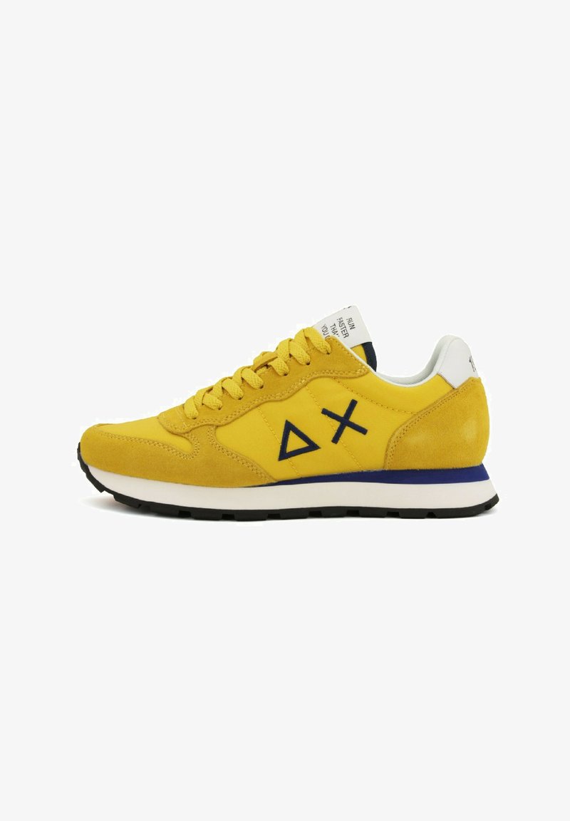 Sneaker in suede giallo con suola bianca, accenti blu e logo con forme geometriche. Presenta lacci tondi e collo imbottito.
