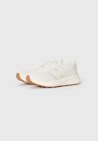 Weiße Sport-Sneaker mit Obermaterial aus Mesh und Textil, ausgestattet mit einer Gummisohle, Schnürung vorne und dezenten grauen Akzenten. Abgerundete Zehenform.