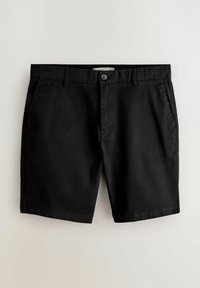 Shorts noirs longueur genou avec fermeture à bouton, passants de ceinture et poches latérales, présentés sur un fond clair uni.