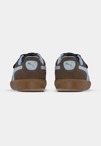 Pruunist seemisnahast kingad helesiniste aktsentidega, millel on tekstuuriga pind, ümar kuju ja kollane logo detail kanna peal.