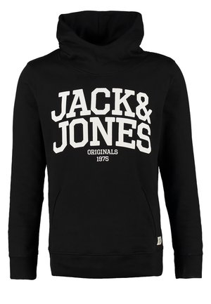 Mann trägt schwarzen Jack & Jones Hoodie, blaue Jeans, schwarze Sneakers und eine Armbanduhr, steht mit einer Hand in der Tasche.