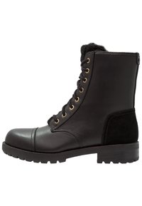 Botas de combate de piel y ante negras con ojales de metal dorado, punta redonda, cuello acolchado y suela de goma con patrón de tracción.