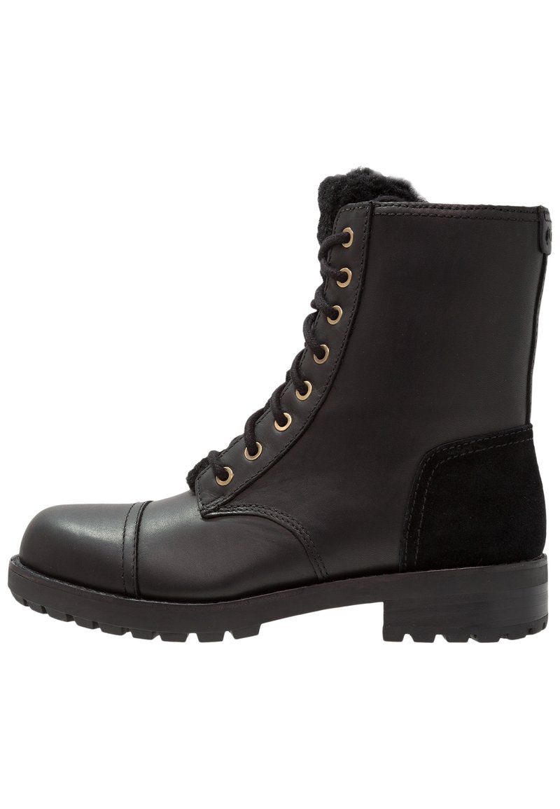 Botas de combate de piel y ante negras con ojales de metal dorado, punta redonda, cuello acolchado y suela de goma con patrón de tracción.