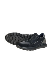 Zwarte sportieve schoenen met een gestructureerd oppervlak, voorzien van grijze suède accenten, vetersluiting en een flexibele rubberen zool met een zigzagpatroon.